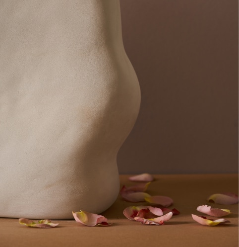 vase en argile avec pétales de rose